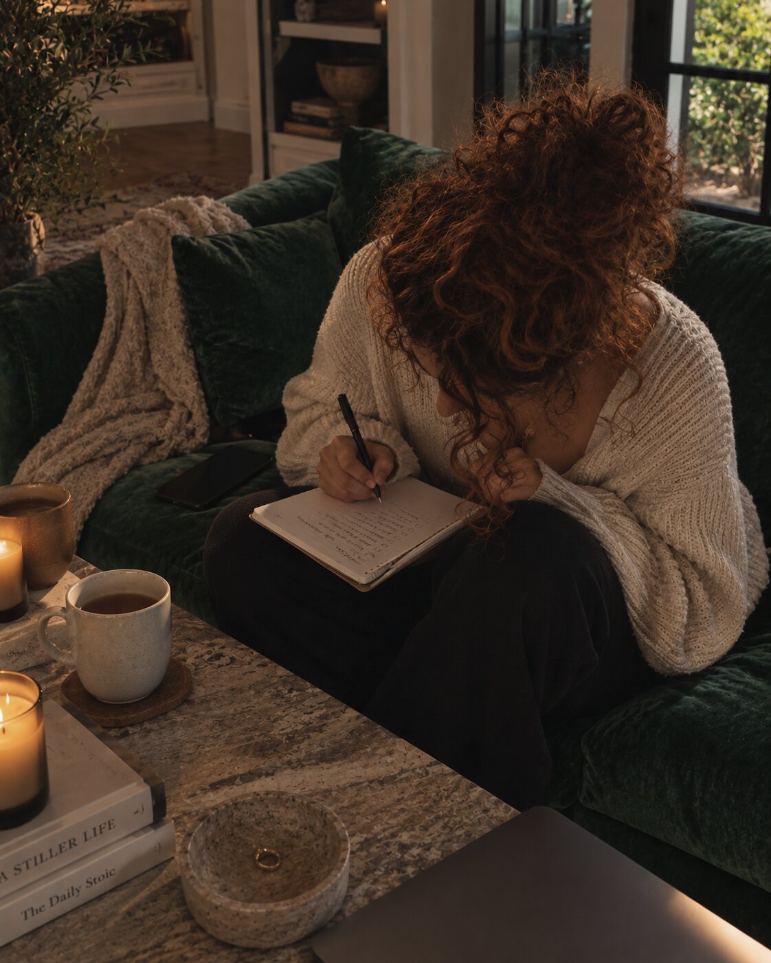 Writing in a journal under a knitted blanket